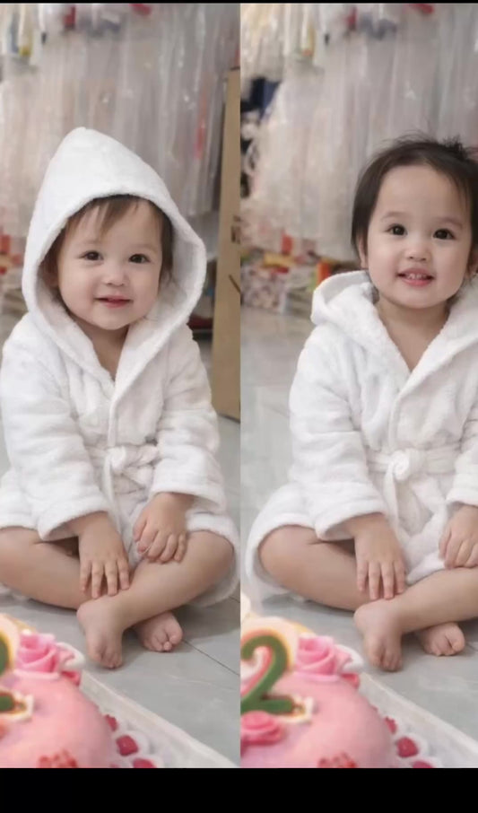 Infant wearing Blank Terry Robe with hood, seated near birthday cake. Soft cotton robe ideal for post-bath comfort and baby gifting.